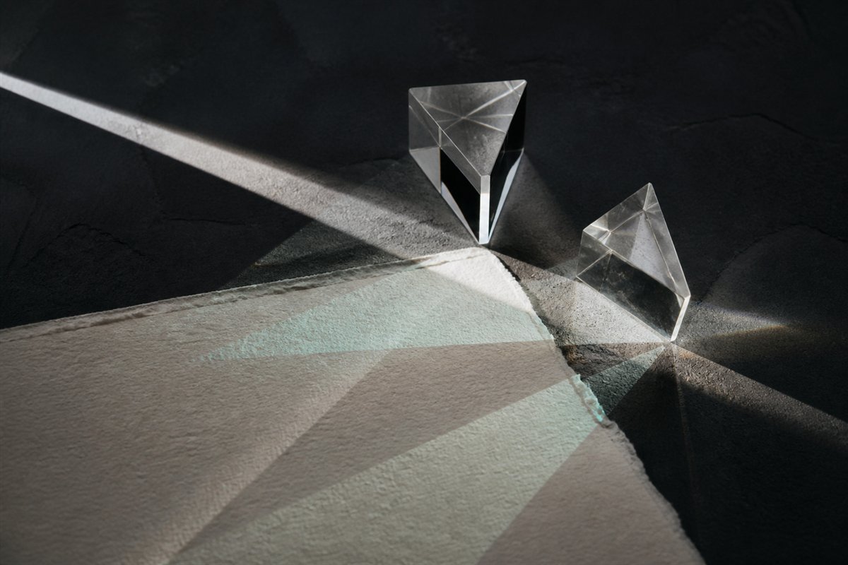 Clear glass prisms separating a narrow beam of light
